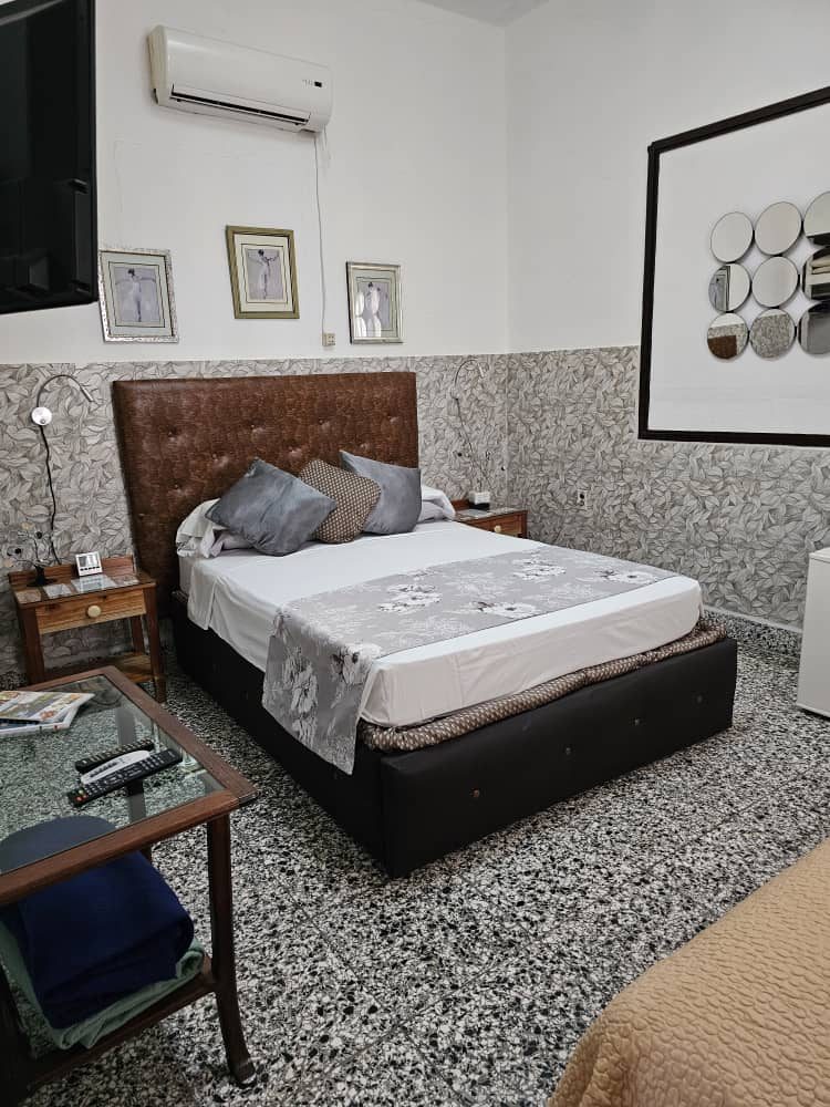 Bedroom with air conditioning, TV and framed prints
