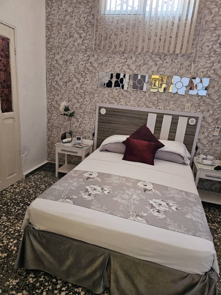 Double bedroom with patterned wallpaper and mirror detail