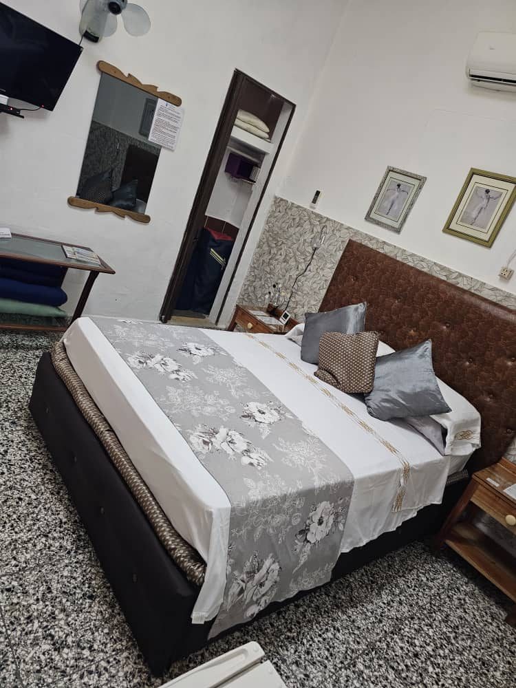 Bedroom with a leather headboard, TV and air conditioning