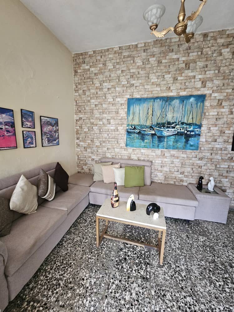 Living room with corner sofa and a sailboat painting