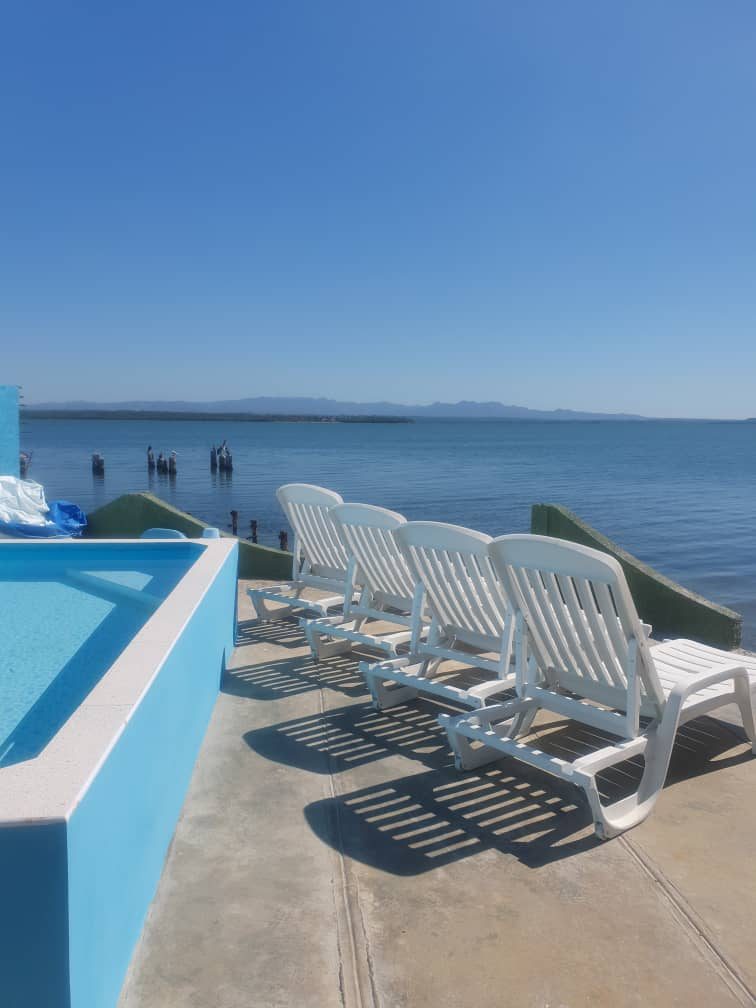 Pool and sun loungers looking out over the bay